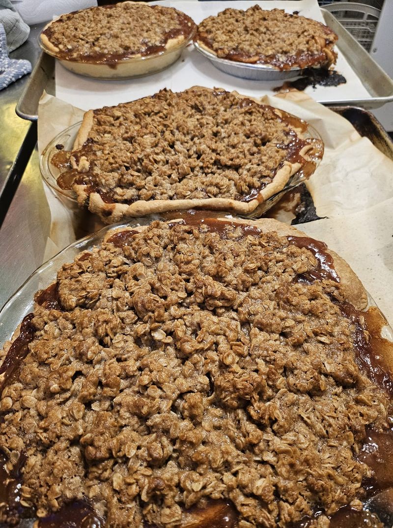 Three apple crumb pies cooling on the rack, crumb tops deep golden